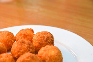 Cheese balls, Breaded mozzarella cheese balls with tomato in white dish on wood blackground