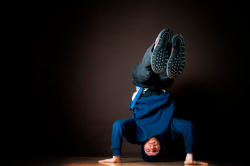 hip hop dancer perform headstand upside down in dark studio b