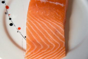 Salmon in white dish on white blackground.