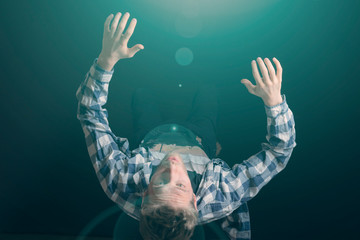 handsome young male levitate in air on dark background b - obrazy, fototapety, plakaty