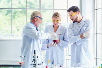 Science teacher and students team working with chemicals in lab