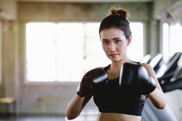 Portrait sporty girl beautiful woman with the back boxing gloves training at the gym