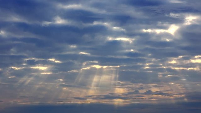 Breathtaking time lapse sky, heavenly clouds with sunbeams penetrating through.