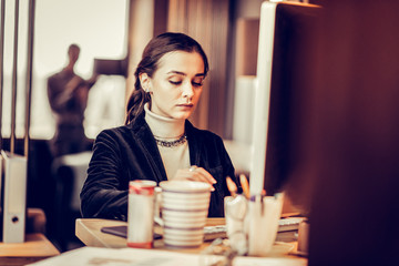 Attentive young brunette female typing message for partner