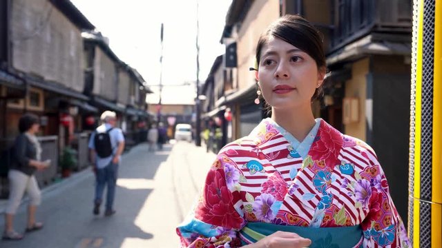 car driving in old town road in background under sunshine. young japanese lady in floral kimono costume walking in kiyomizu zaka street going to shopping join festival in summer on holidays.