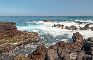 Fototapeta na wymiar Waves breaking along the rocks in Tenerife, in the Canary Islands on a sunny day.