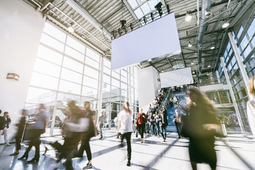 Anonymous blurred business people rushing in a hall of a trade fair