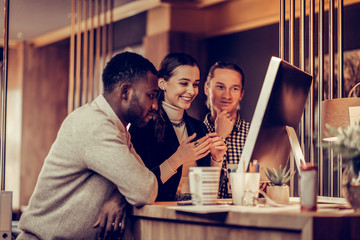 Cheerful young female standing between her colleagues