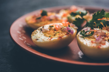 Fried hot boiled egg masala is a popular healthy breakfast or starter menu from India. With onion, coriander, black pepper, tomato and salt sprinkled over half of eggs