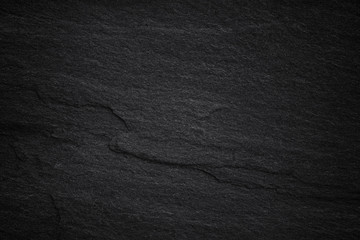 Dark grey black slate background or natural stone texture.