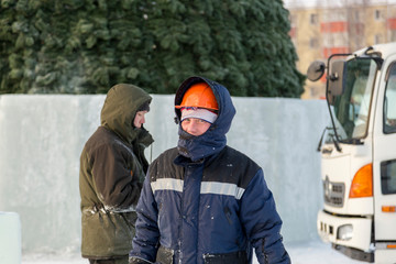 Portrait of an assembler in an orange helmet