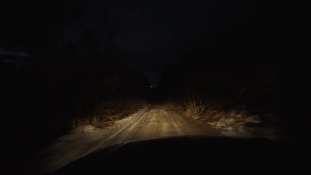 night driving on a dirt road in the mountains. snow and mud