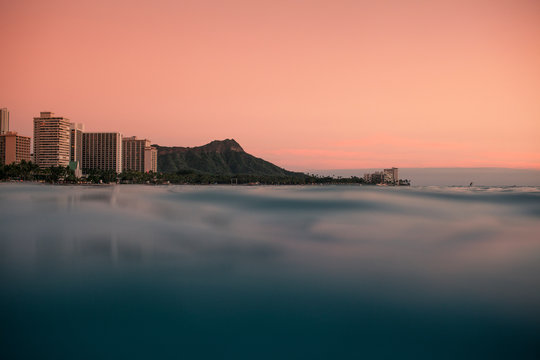 A pink sky forms as the sunsets off of Diamond Head on Oahu Hawaii