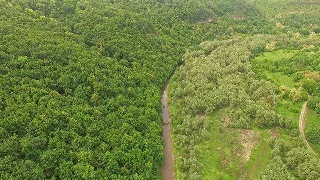 Amazing aerial view of mountain forest and river valley with small bridge