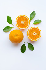Fresh orange citrus fruit slices with leaves on white background.