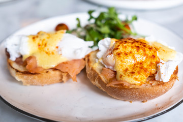 Eggs Benedict, English muffin topped with a poached egg, smoked salmon, and hollandaise sauce.