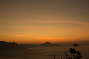 Beautiful sky sunrise. Mountain layer in morning sun ray and winter fog.