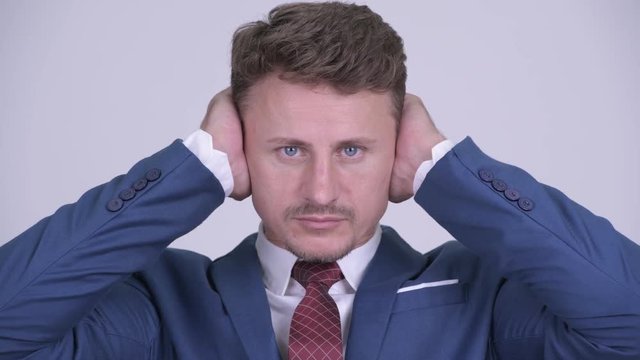 Face of bearded businessman showing three wise monkeys concept
