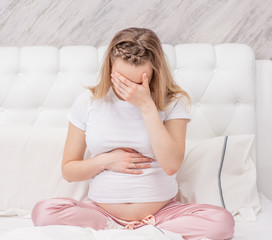 Sad pregnant woman suffering from headache