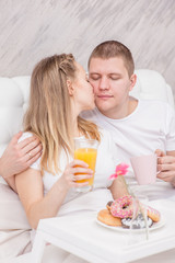 Obraz na płótnie Canvas Happy young family. Romantic couple having breakfast in bed