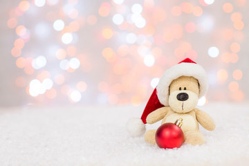 Toy bear with red santa hat and tree toy ball. Christmas holidays background with copy space for your text