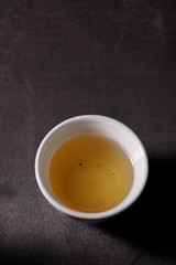 Piala with freshly brewed vitamin drink on herbs on a dark background.