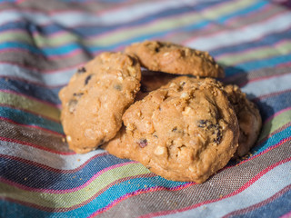 Cookies raisin and macadamia nuts on nature background and stripe fabric texture