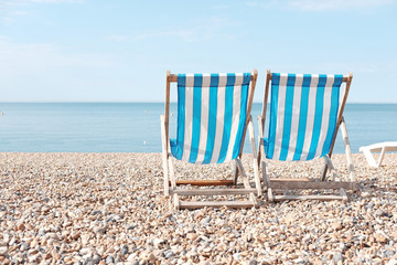 Two stripe beach chair on a beach.