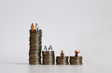 Concept of income inequality by stratum. Miniature people with a pile of coins. 