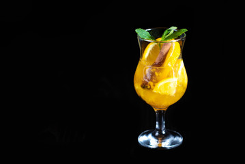 Winter warming drink with pieces of orange and spices on a black background. Restaurant serving