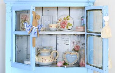 Vintage interior of retro, vintage wooden light blue sideboard and the old beautiful set of dishes