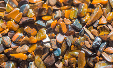 Many raw cat's quartz minerals, brown cat's eye stones texture background