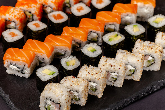 The concept of Japanese and Chinese cuisine. Set from sushi and rolls lie on a stone blackboard. Background image.