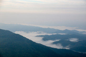 Naklejka premium Distant hills and mountains above a sea of fog and mist, the mist in winter Landscape, view from top of mountain at Doi Phu Co, Mae Hong Sorn, Thailand 