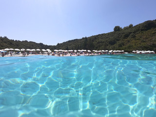 Underwater photo of mediterranean paradise island sandy beach with turquoise clear sea