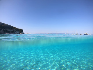 Underwater photo of mediterranean paradise island sandy beach with turquoise clear sea