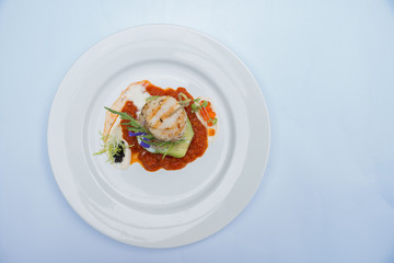 Grilled scallops, tomato sauce in a white dish