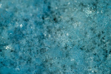 Obraz premium New Year and Christmas abstract icy snowy background with real snowflakes macro in cold blue tones. Cold winter background