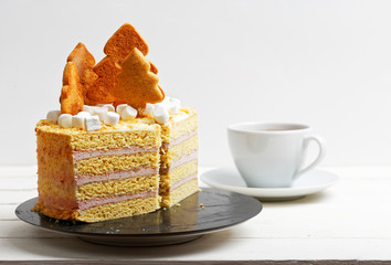 Honey cake decorated with white cream, cookies and marshmallow