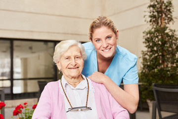 Pflegehilfe und Senior Frau zusammen