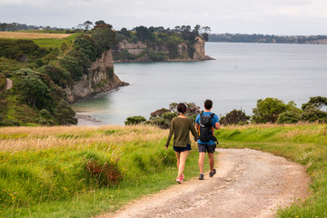 young couple walking on long bay beach