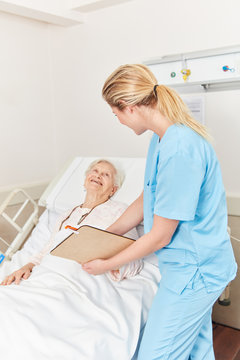 Krankenpflegerin am Bett einer Patientin