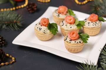 Tartlets with avocado paste and salted salmon on a white plate