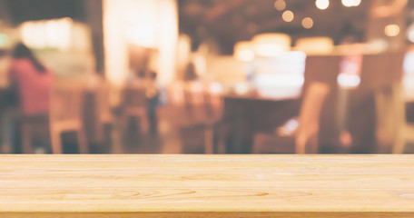 Wood table top with Restaurant cafe or coffee shop interior with people abstract defocused blur background