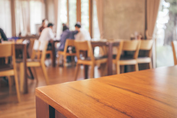 Restaurant interior with customer and wood table blur abstract background with bokeh light