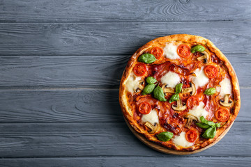 Delicious pizza on wooden background, top view