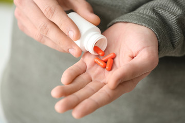 Young man with bottle of pills, closeup