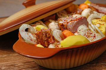 Homemade smoked meat and vegetables ready for cooking in ceramic bowl. Sweet and plain potato, carrot, champignon mushrooms garlic and onion.