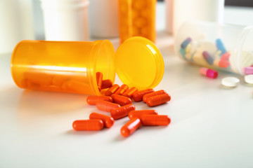 Plastic container with pills on table