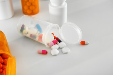 Plastic containers with pills on table